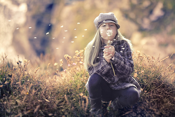 girl blowing dandelions
