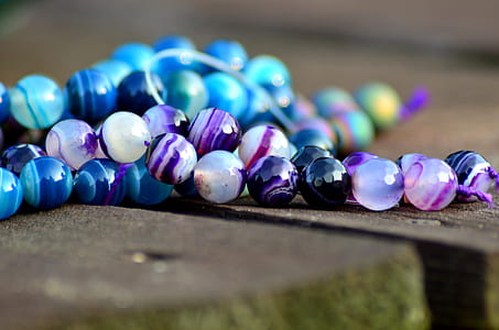 shallow focus photography of beaded white and purple necklace
