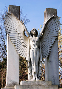 statue of angel under blue sky