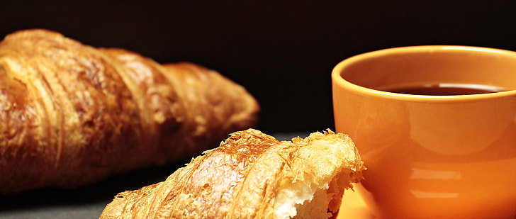 baked croissant near brown ceramic mug