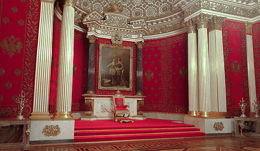 gold and red armchair on red area rug