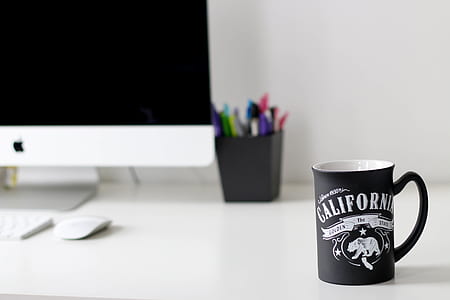 black California printed ceramic mug near iMac