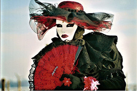woman wearing black dress holdiing red lace fan