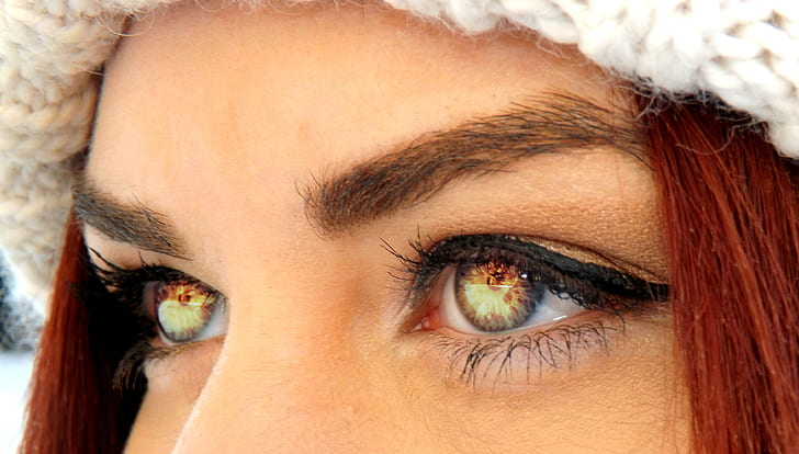 photo of woman's eyes reflecting fire