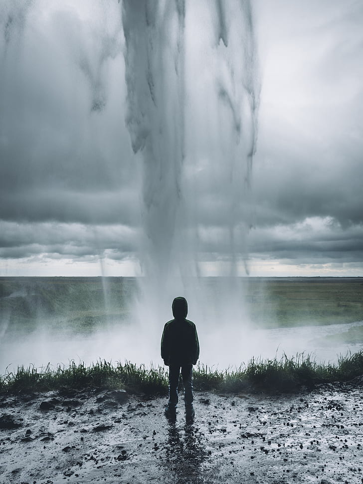 person standing facing on geyser photograph