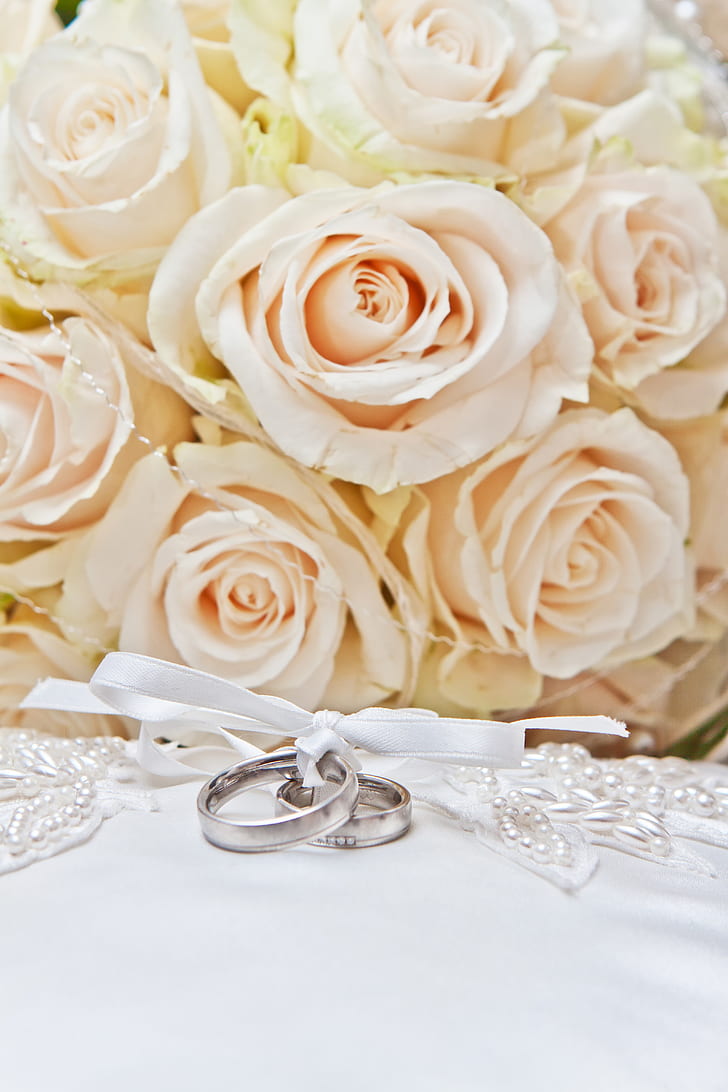 white flower bouquet and two silver-colored rings