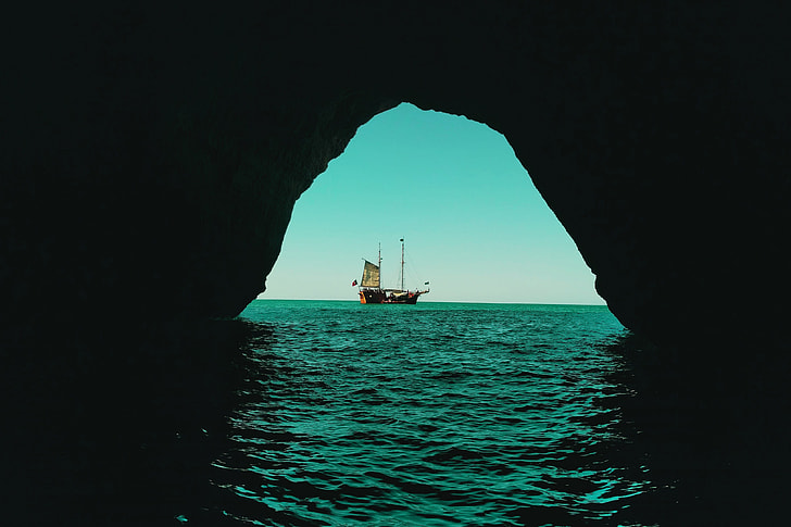 View of a boat from an ocean water cave