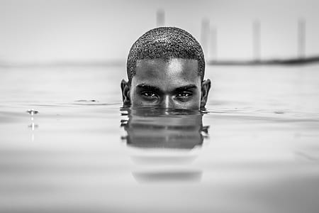 macro photography of half-face of man's head underwater