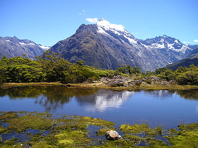 photo of mountain near trees and body of water