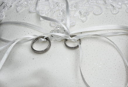 two silver-colored rings tied with white ribbons