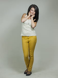 woman in white tank top and yellow jeans