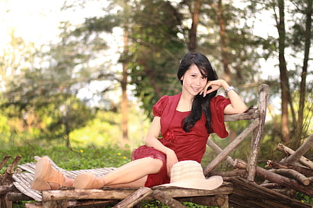 girl wearing red dress near trees
