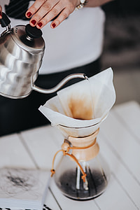 Woman pouring water in Chemex filter coffee maker