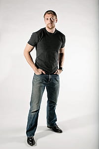 man in black crew-neck shirt and blue-washed jeans