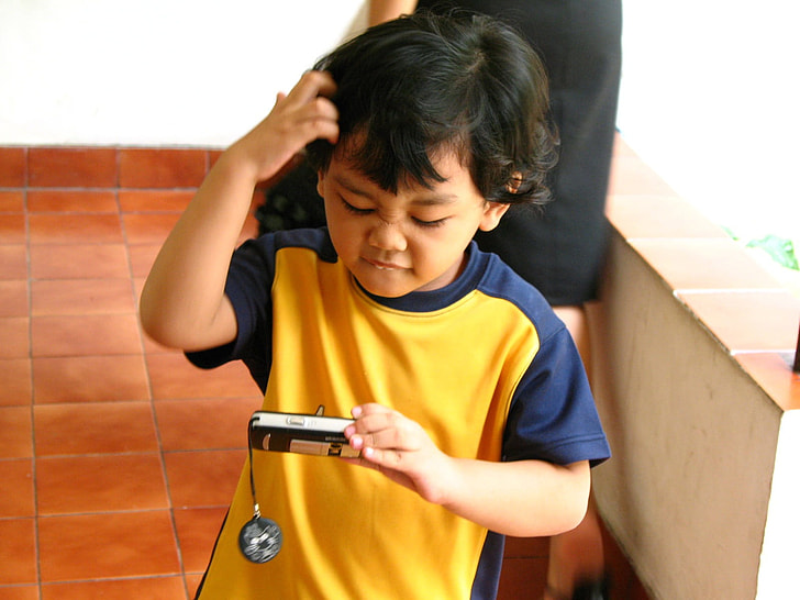 boy holding point-and-shoot camera