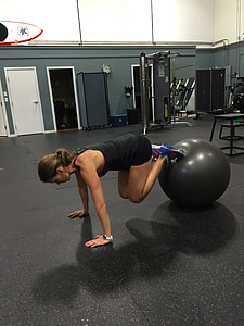 woman in black tank top using stability ball