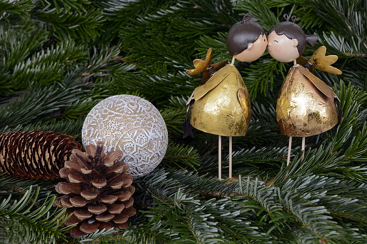 two brown pine cones with white and brown bauble