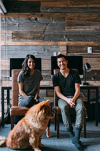 photo of two person and dog sitting on room