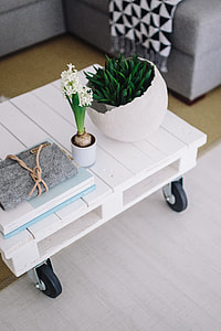 Small wooden table with a potted plant and a grey wallet