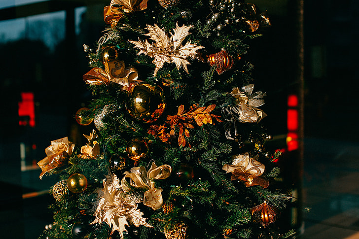 brown and gold-colored ornaments on green Christmas tree