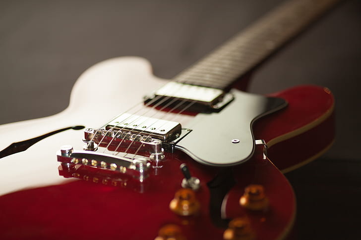 shallow focus photo of red telecaster electric guitar