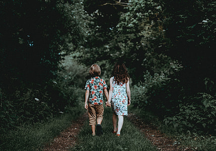 Siblings walking, holding hands