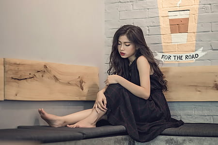 woman in black sleeveless dress sitting