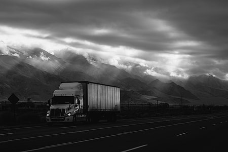 grayscale photo of freight with trailer during daytime