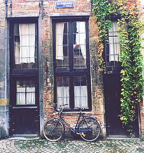 blue dutch bike on brown concrete brick wall house