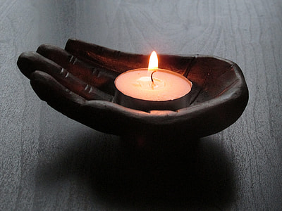 black wooden hand candle holder