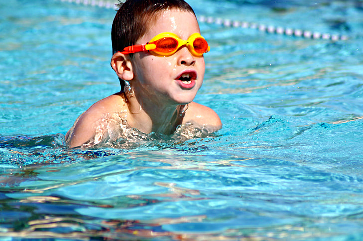 boy wearing diving goggles swiming