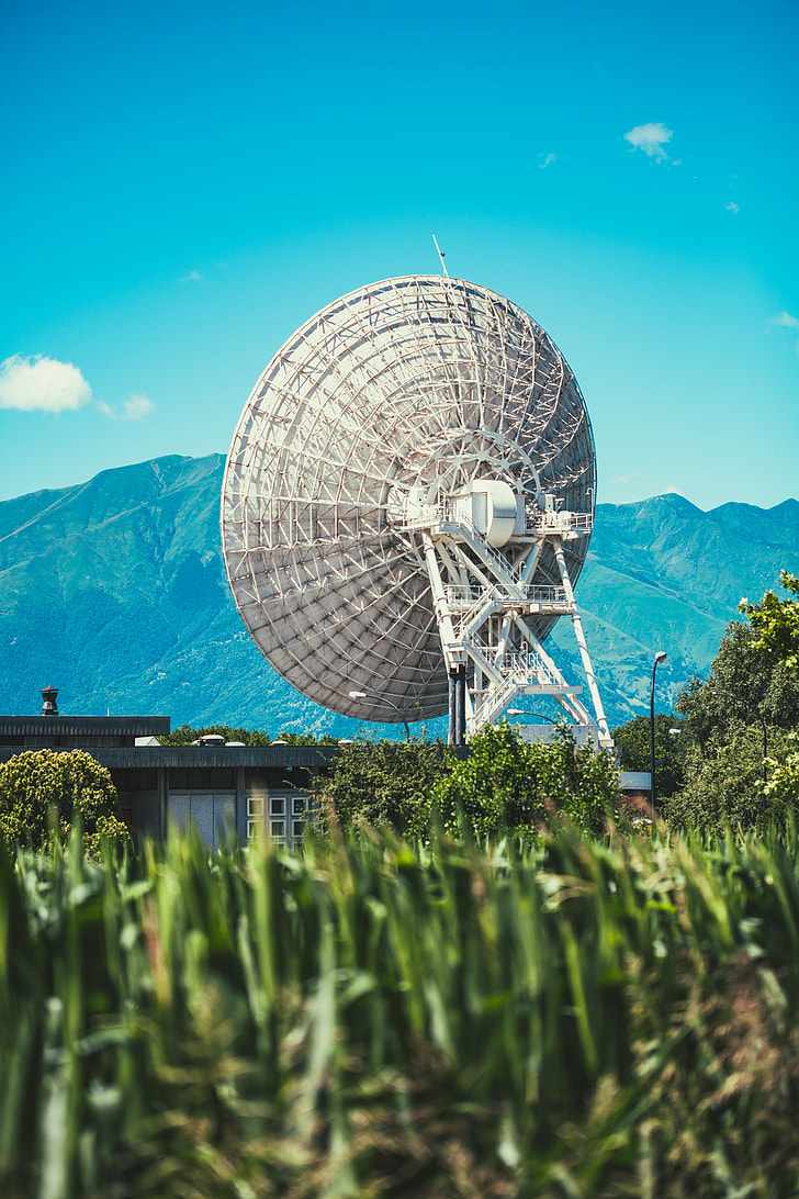 selective focus photography of parabolic antenna and mountain range view