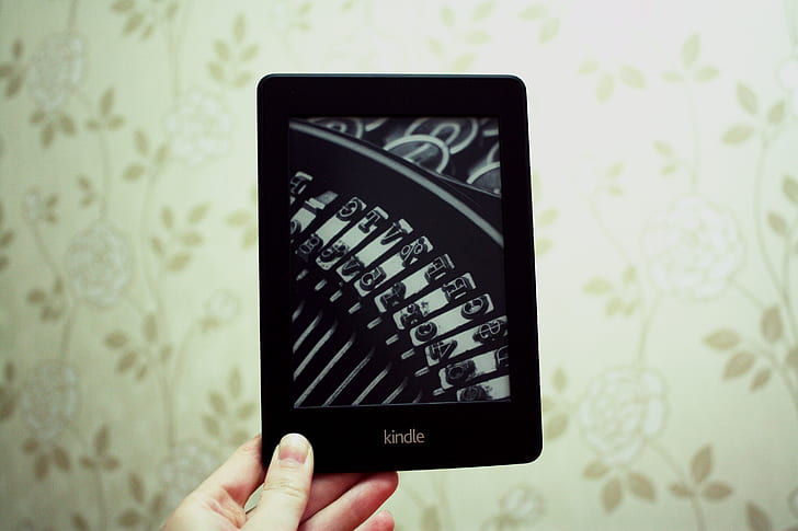 person holding black Kindle tablet