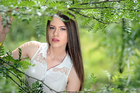 woman wearing white lace button-up sleeveless top under shade of tree