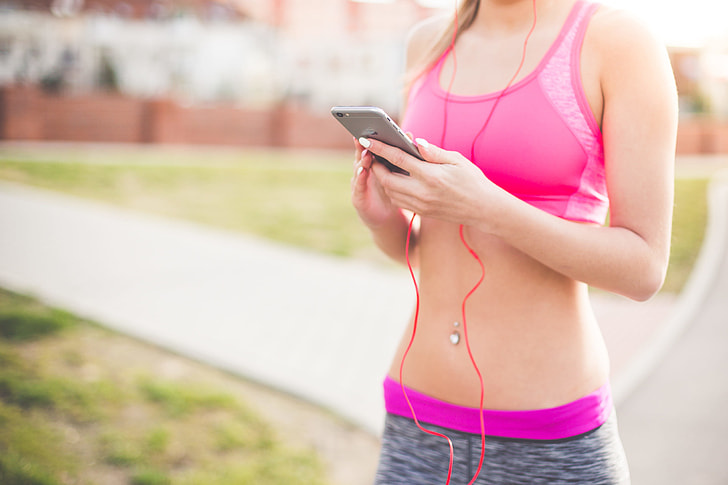 Fitness Girl Listening to Streaming Music on Her Phone
