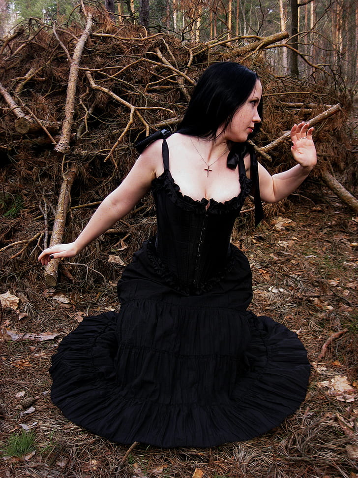 woman wearing black sleeveless dress on forest