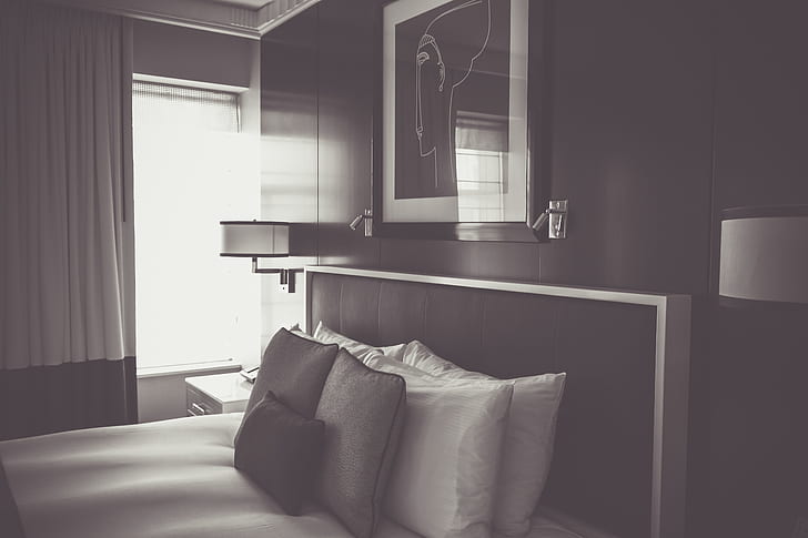 grayscale photo of bed and photo frame