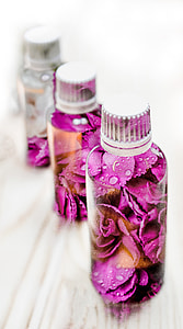 shallow focus photography of pink flowers in glass bottles