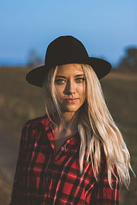 tilt shift lens photography of woman wearing red and black plaid button-up top and black hat