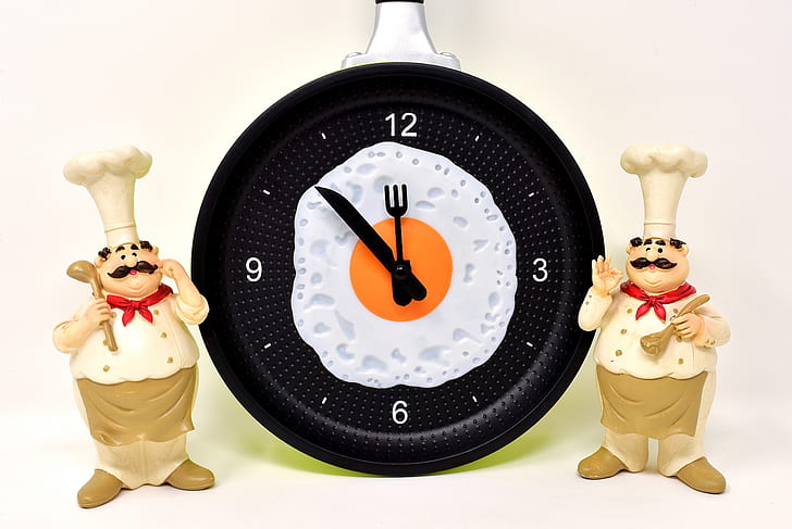 two chef figurines beside analog clock displaying 11:52