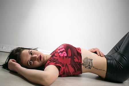 woman in red crop top with rose waist tattoo