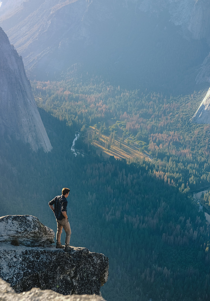 man on mountain cliff during daytime