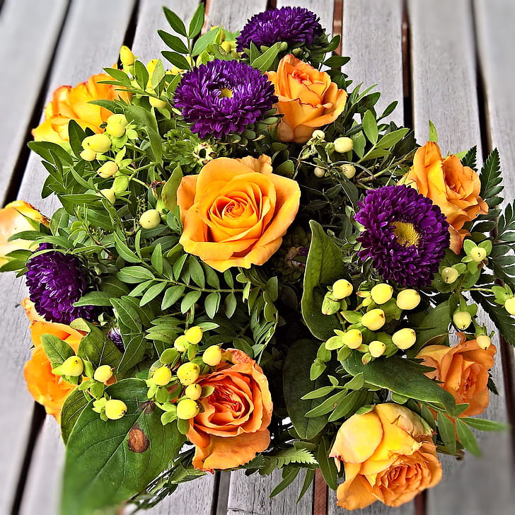 yellow, purple, and green flower center piece on brown wooden surface
