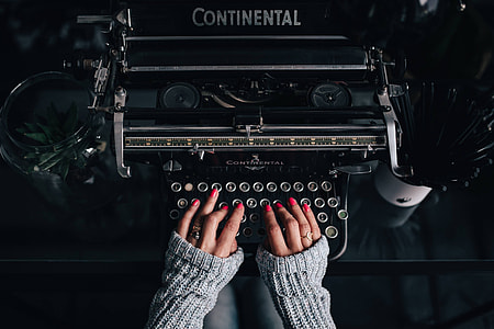 Woman typing on an old typewriter