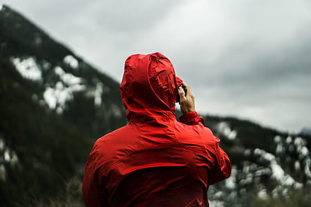 selective focus photography of person wearing red hooded jacket