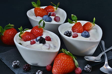 strawberry with cream in white ceramic bowls