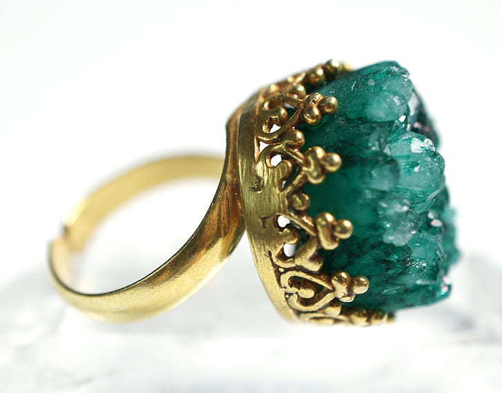 closeup photo of gold-colored ring with green gem
