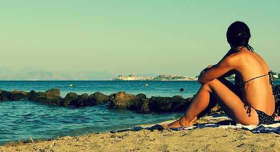 woman wearing black bikini near sea during daytime