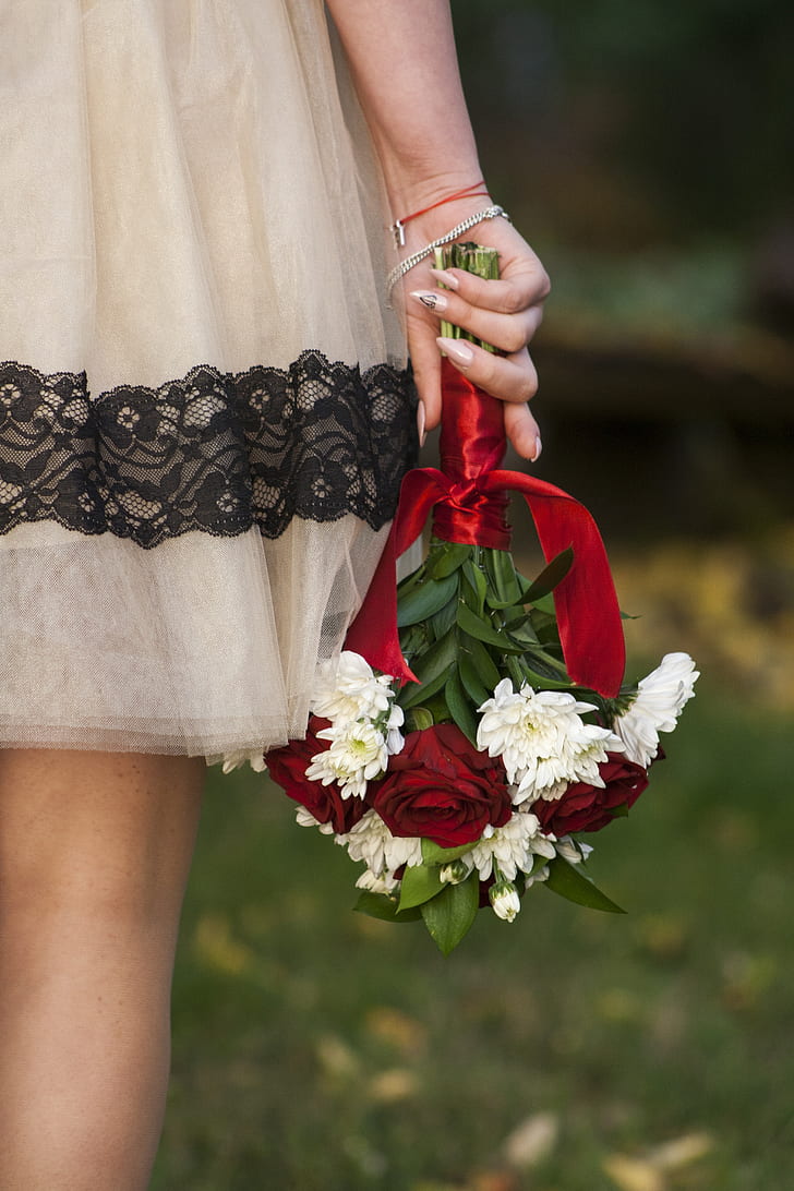 woman holding bouquet of white flowers