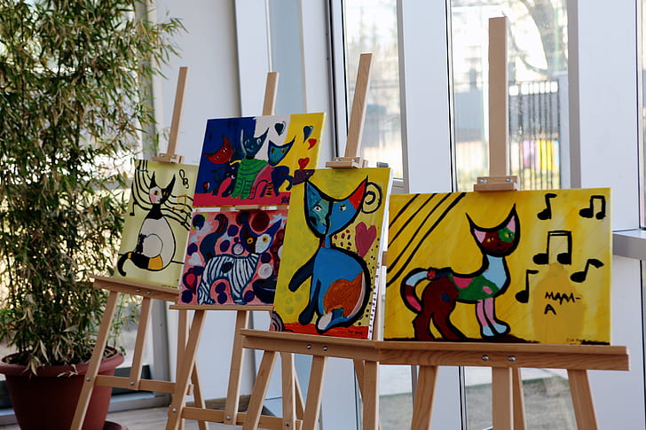 five cat paintings with easels